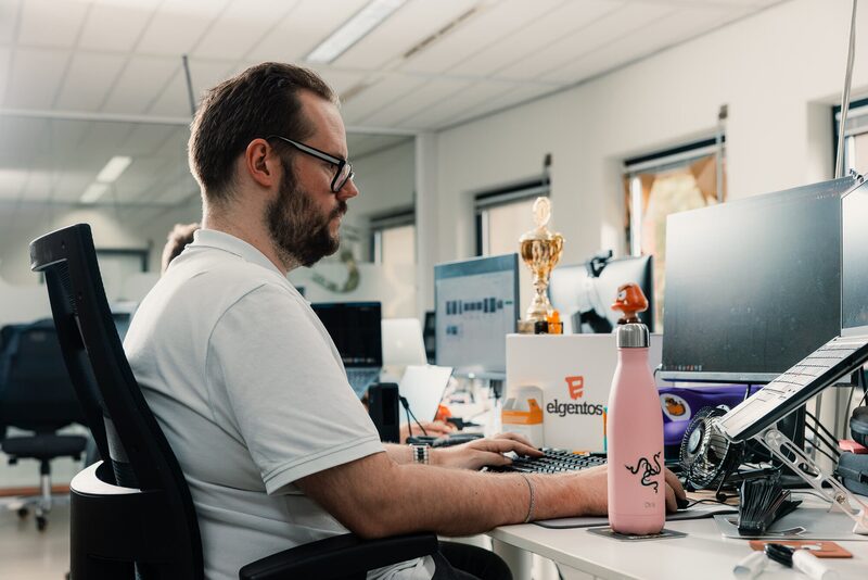 Developer aan het werk achter twee schermen