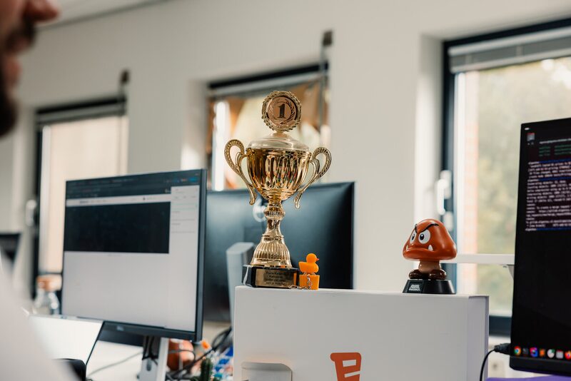 Beker op een bureau tussen de schermen